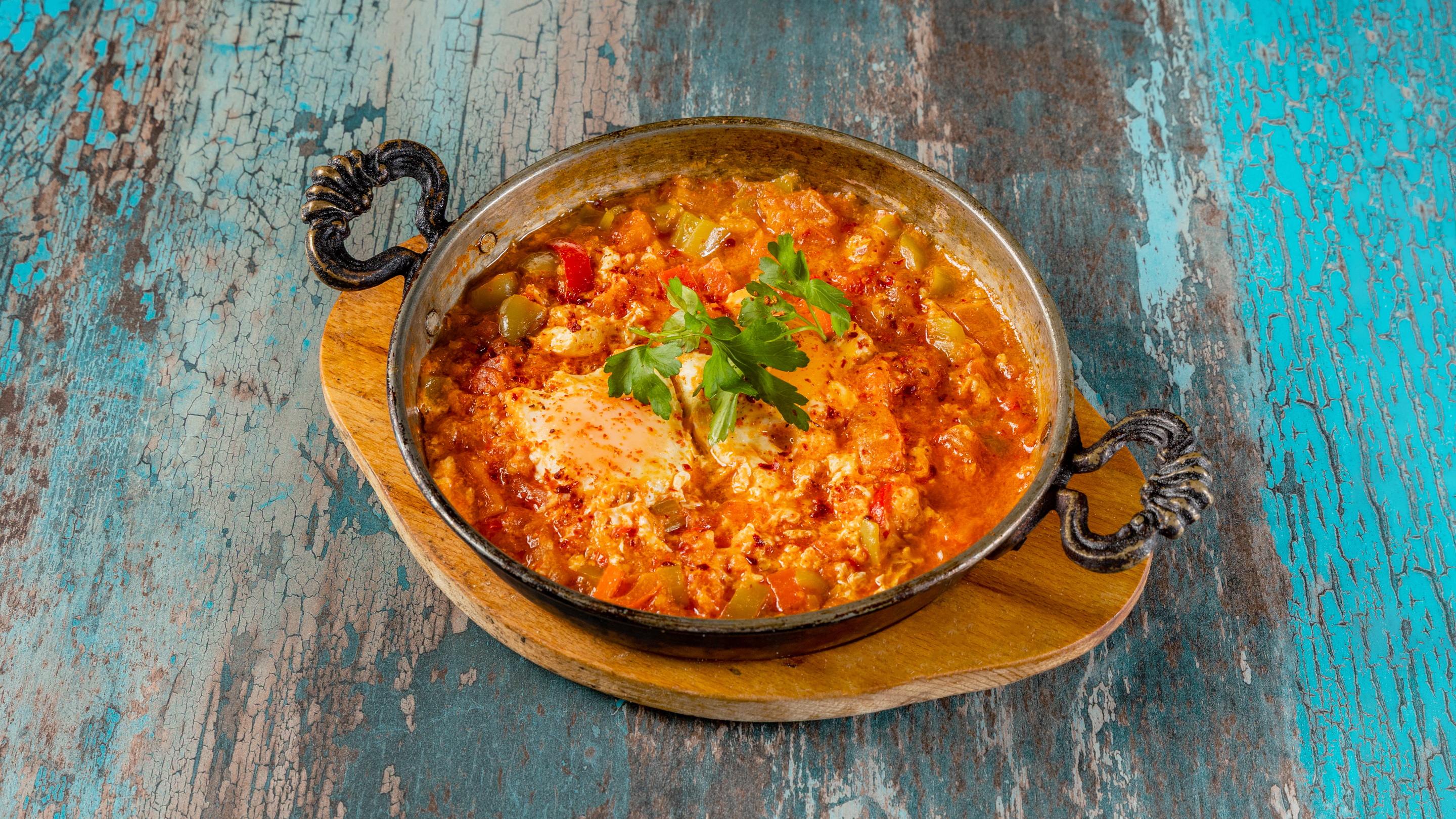 Menemen — Turkish scrambled eggs with tomatoes and peppers in a cast iron pan