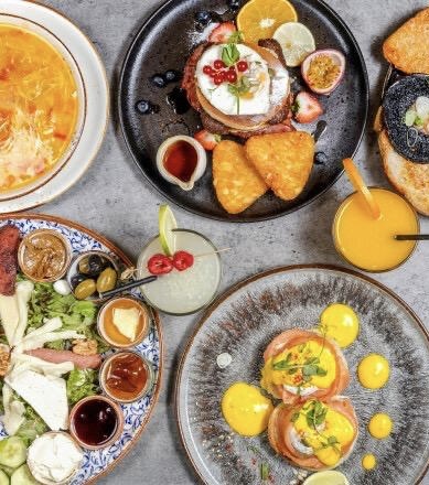 Beautiful brunch spread at The Olive Cafe Palmers Green — poached eggs, avocado toast, lemonade and coffee